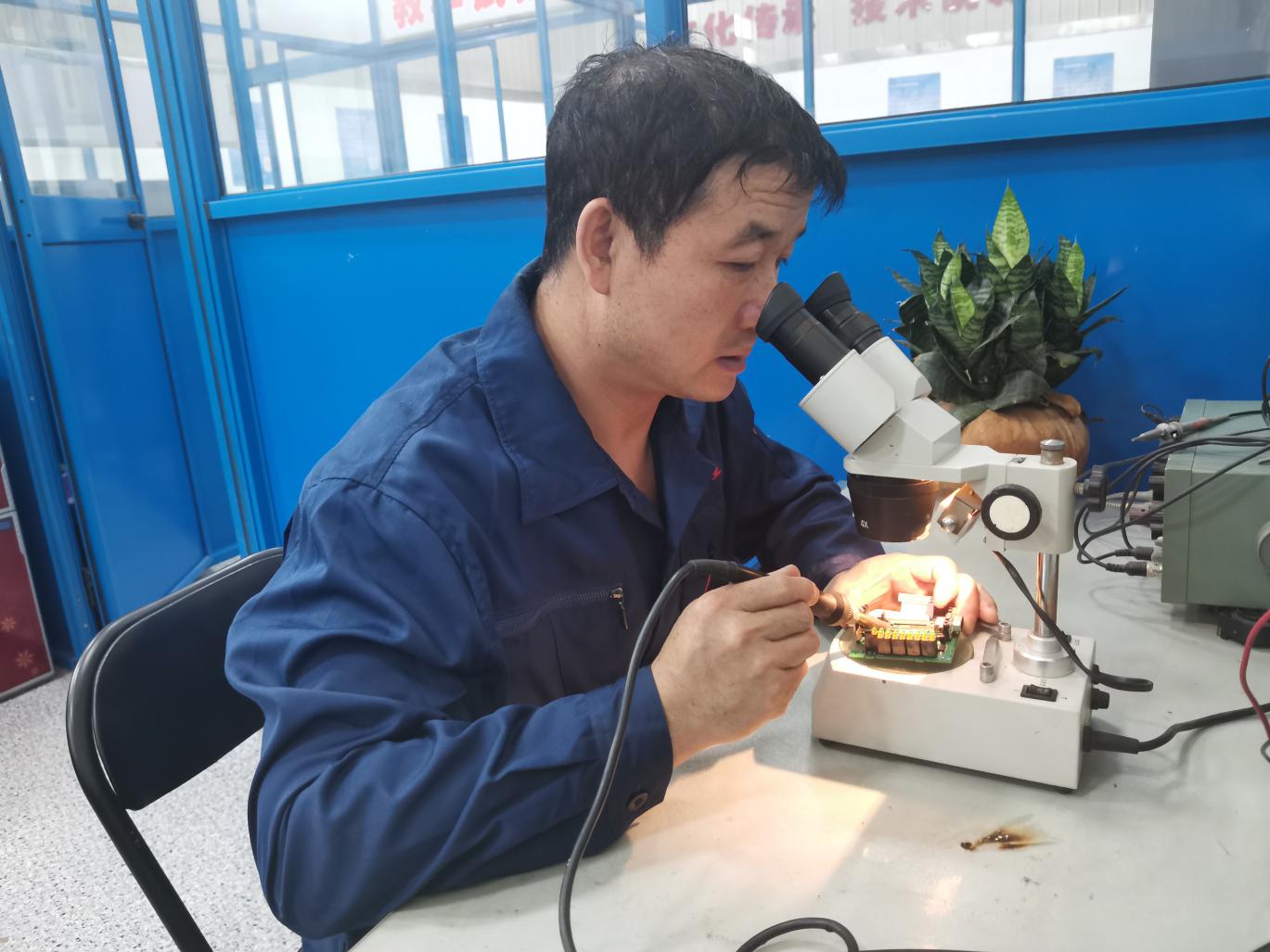 王文超工作照2：王文超用电子显微镜在检查元件